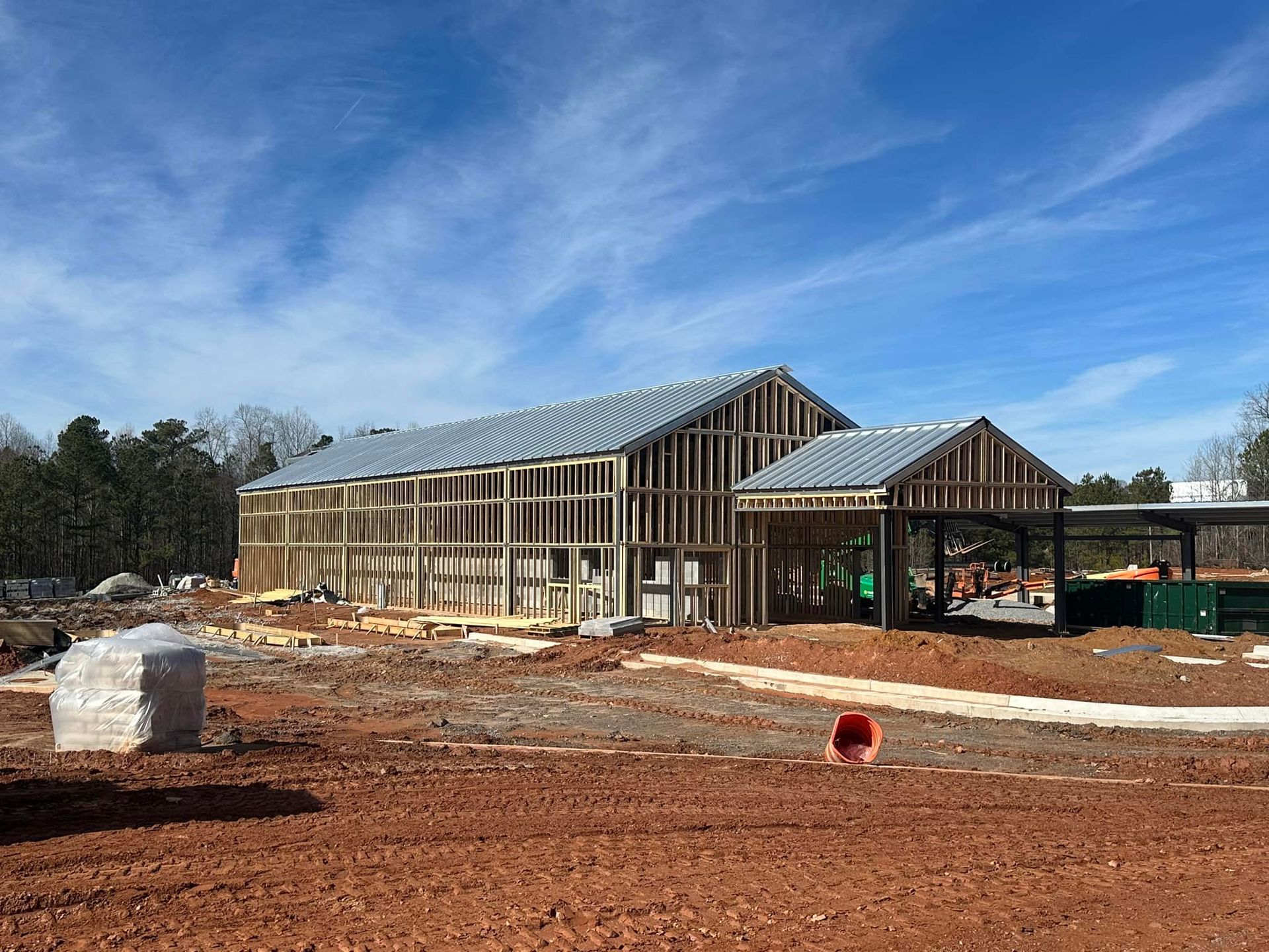 A large building is being built in the middle of a dirt field.