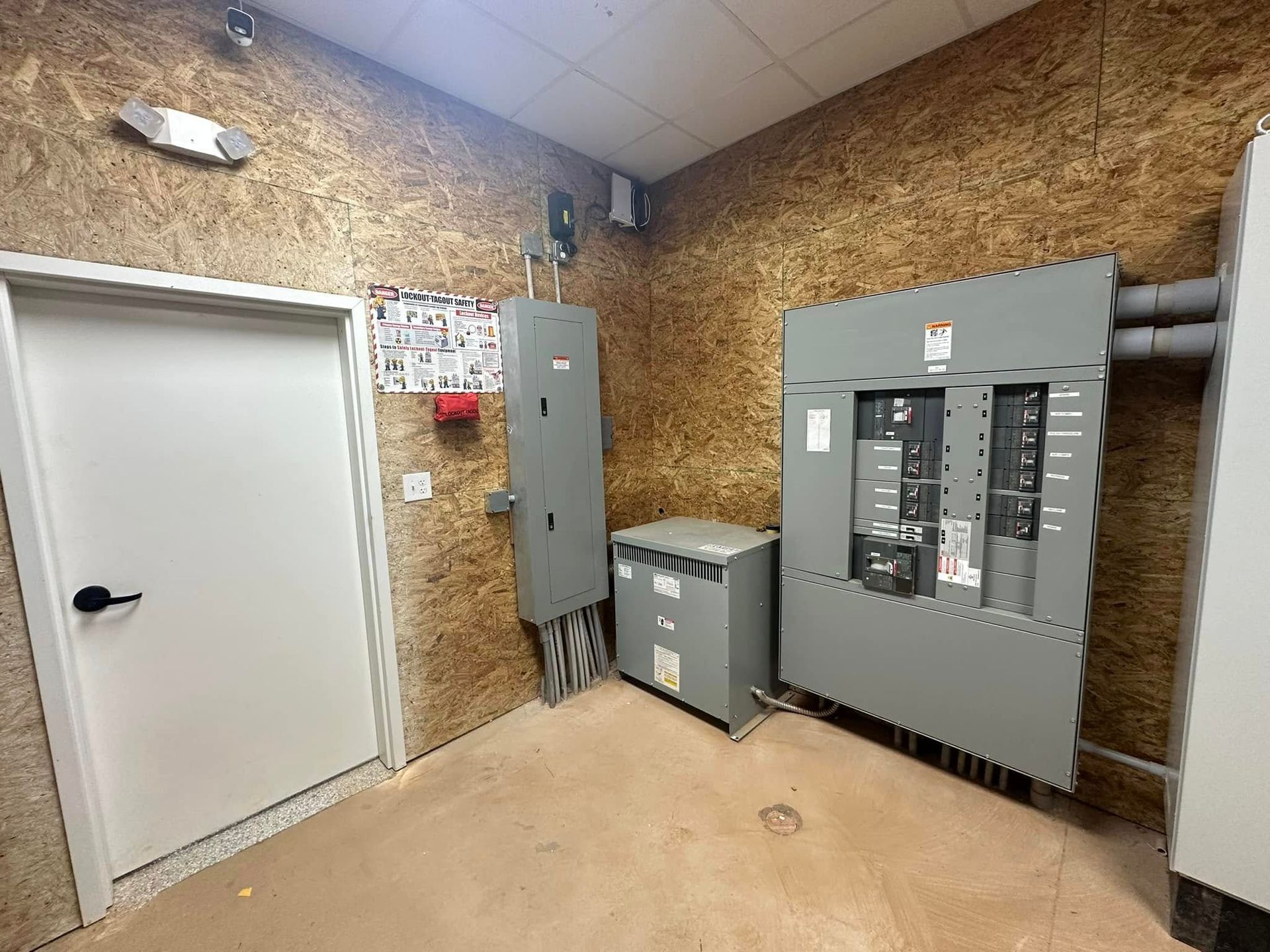 A room with a lot of electrical equipment and a door.