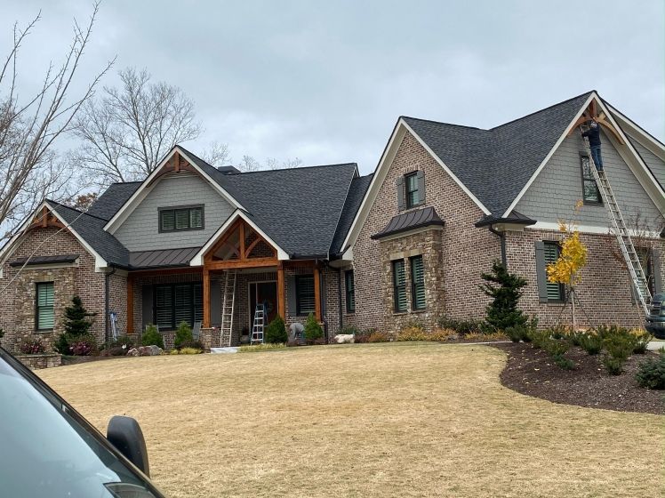 A large brick house with a car parked in front of it.