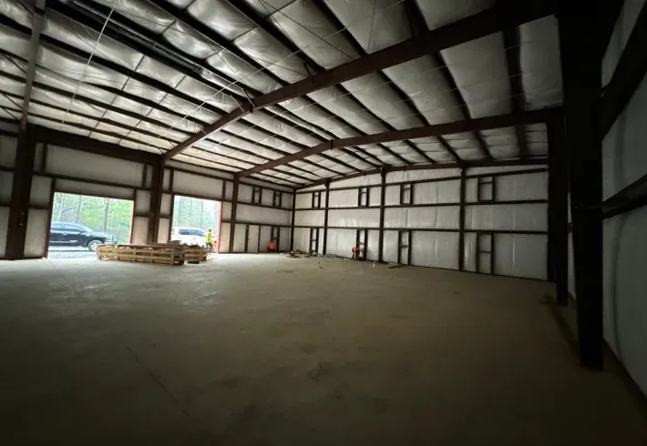 The inside of a large warehouse with a large door.