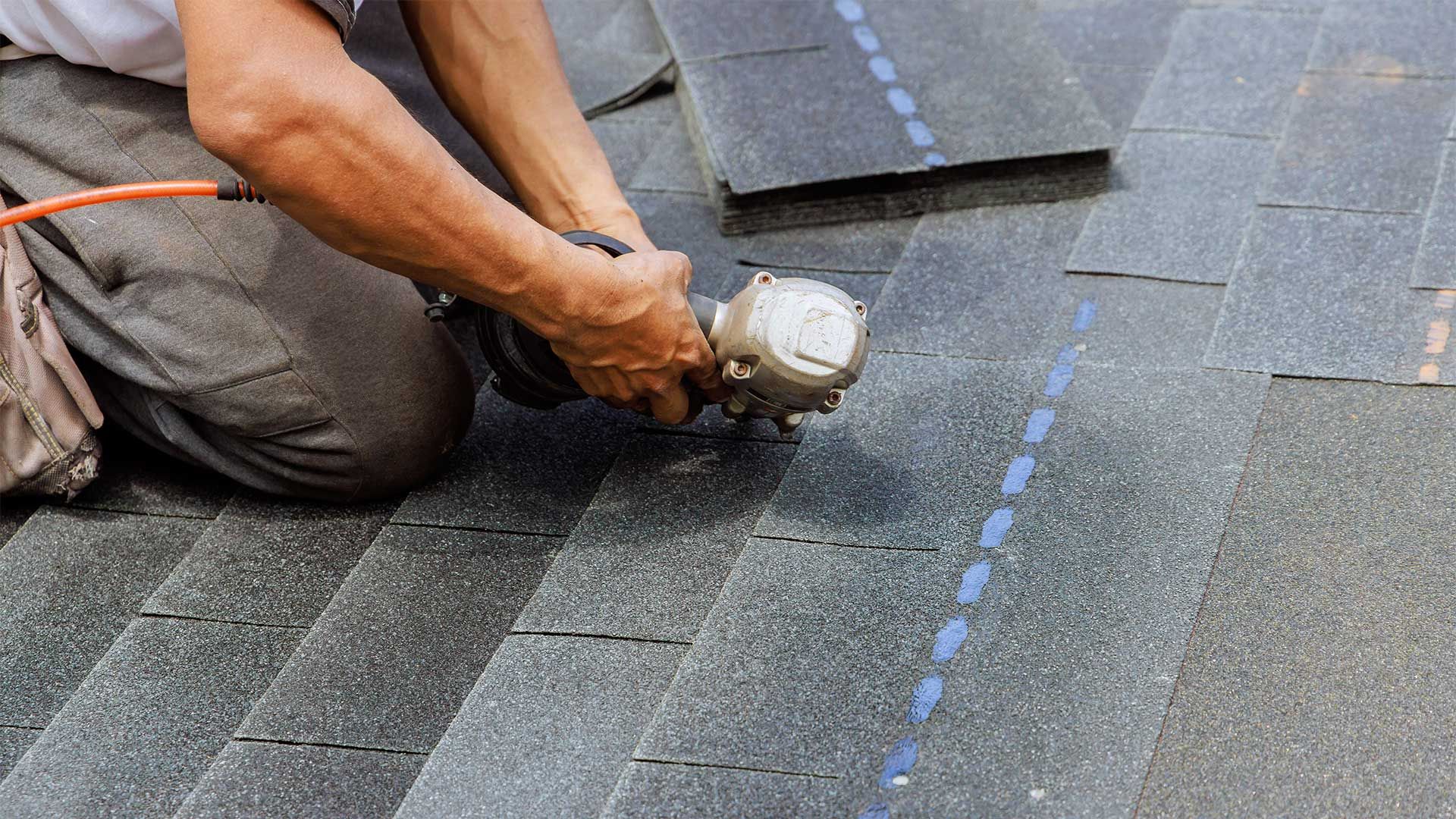 A man installing a shingle roof