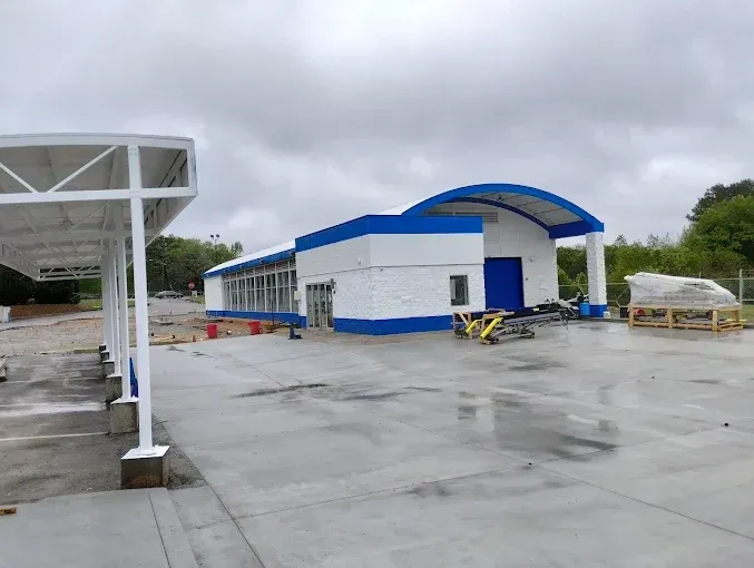 A blue and white building with a canopy on a cloudy day