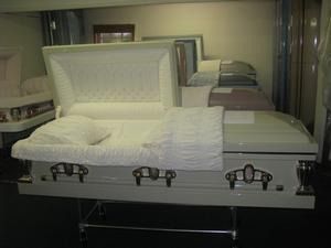 Open casket with white lining and pillow in a funeral setting