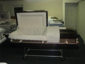 Open casket with white lining in a funeral home room