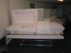 White casket with open lid in a funeral home viewing room