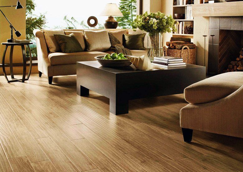 A living room with a couch , chair , coffee table and fireplace