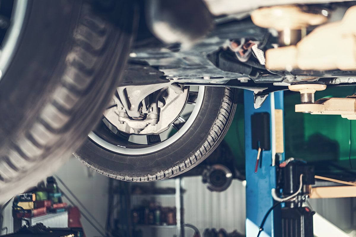 A Car Is Sitting On A Lift In A Garage — Cameron Brothers Automotive In Currajong, QLD