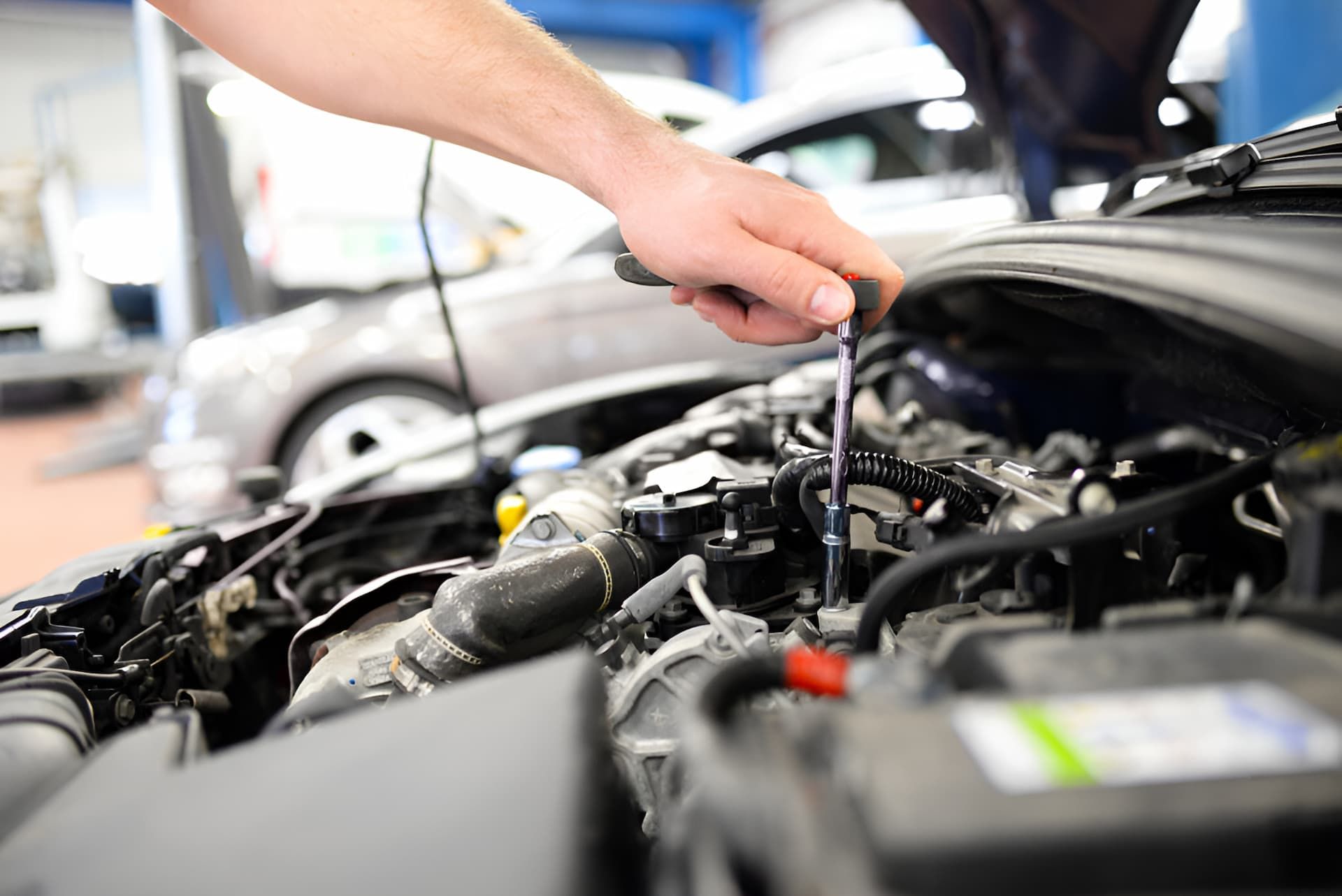 A Man Is Working On The Engine Of A Car With A Wrench — Cameron Brothers Automotive In Currajong, QLD