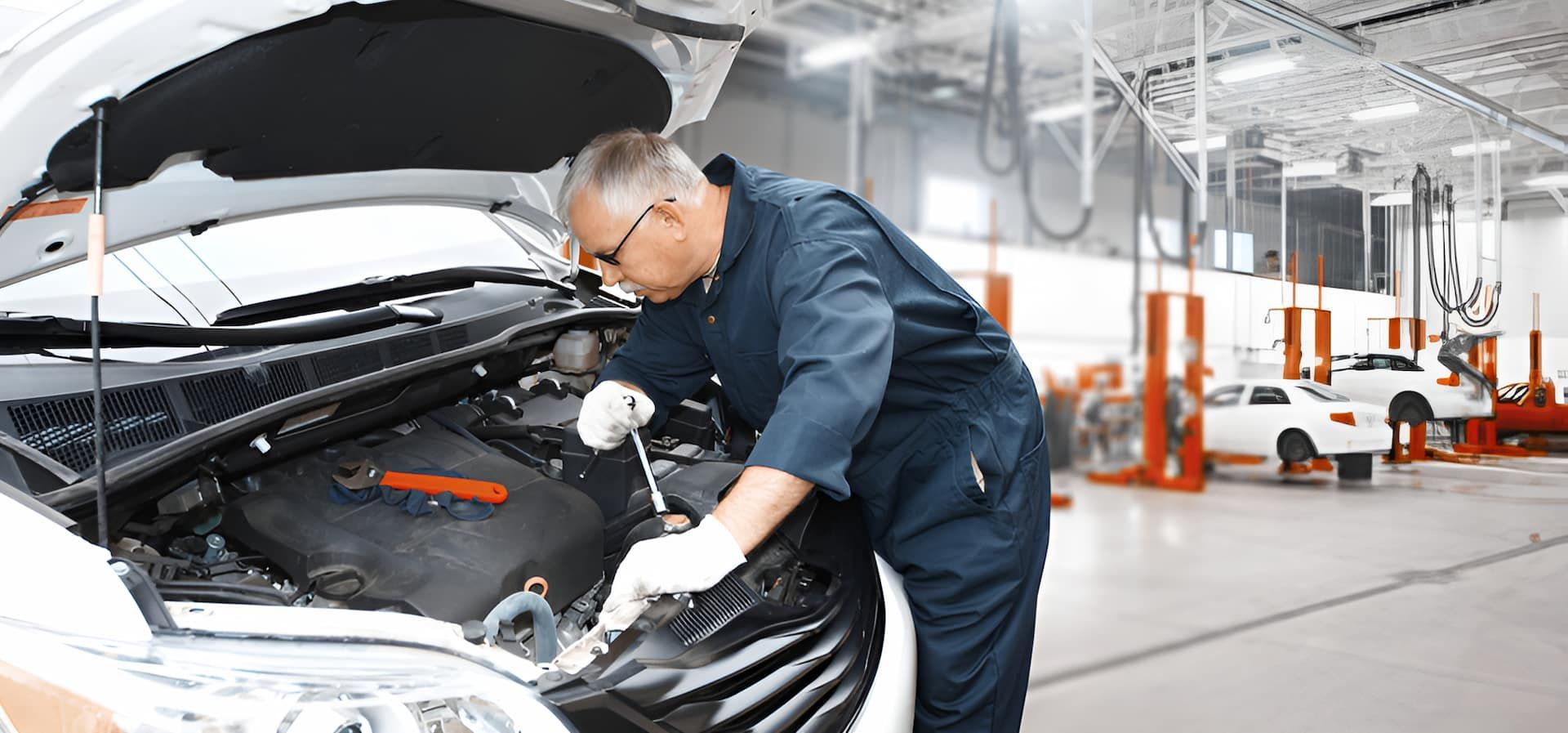 A Mechanic Is Working On The Engine Of A Car In A Garage — Cameron Brothers Automotive In Currajong, QLD