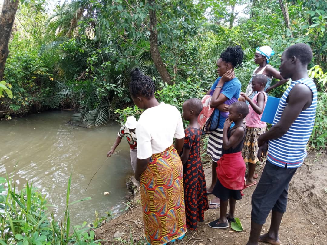 A group of people are standing next to a river.