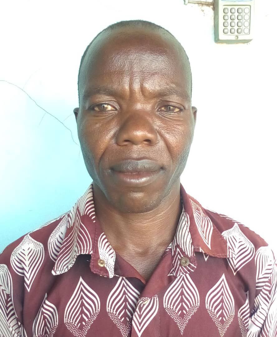 A man wearing a maroon shirt with white leaves on it