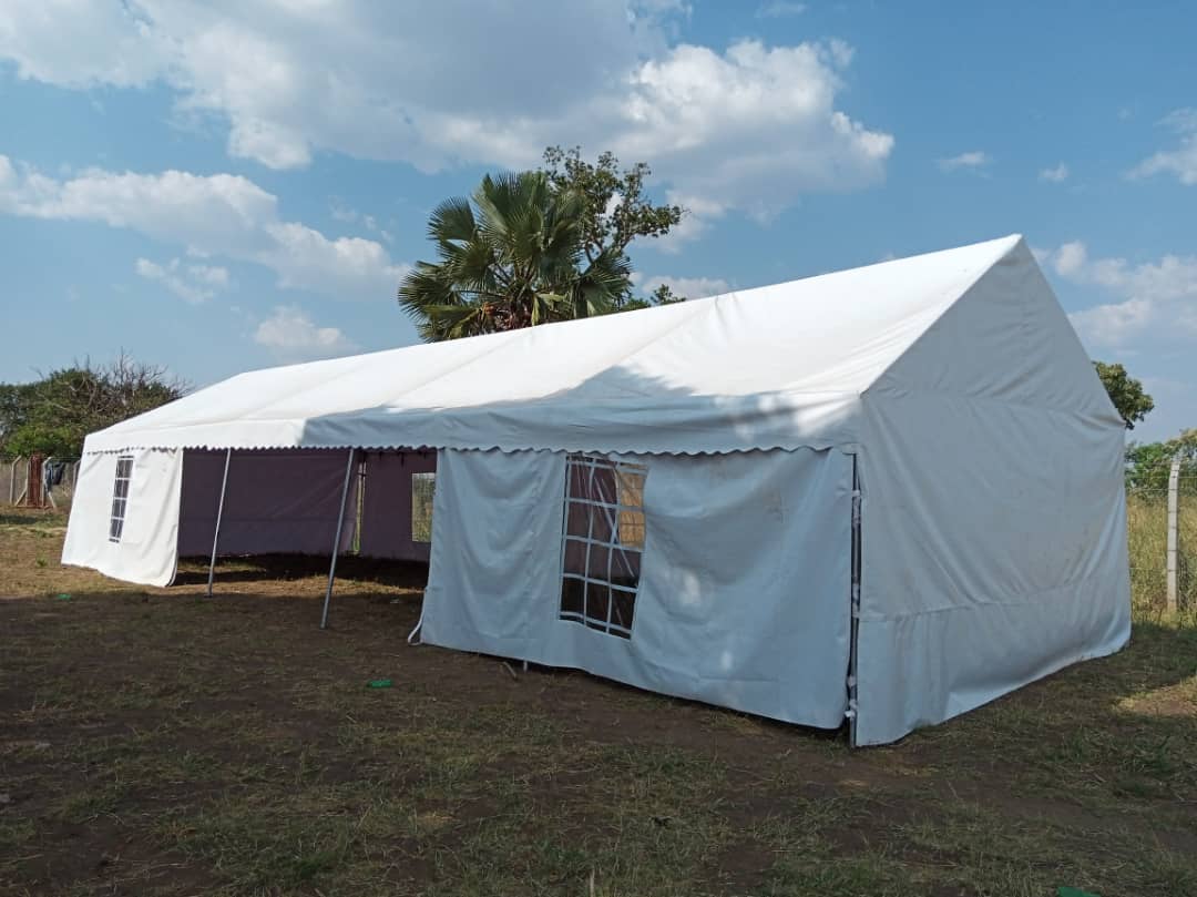 A large white tent is sitting in the middle of a field