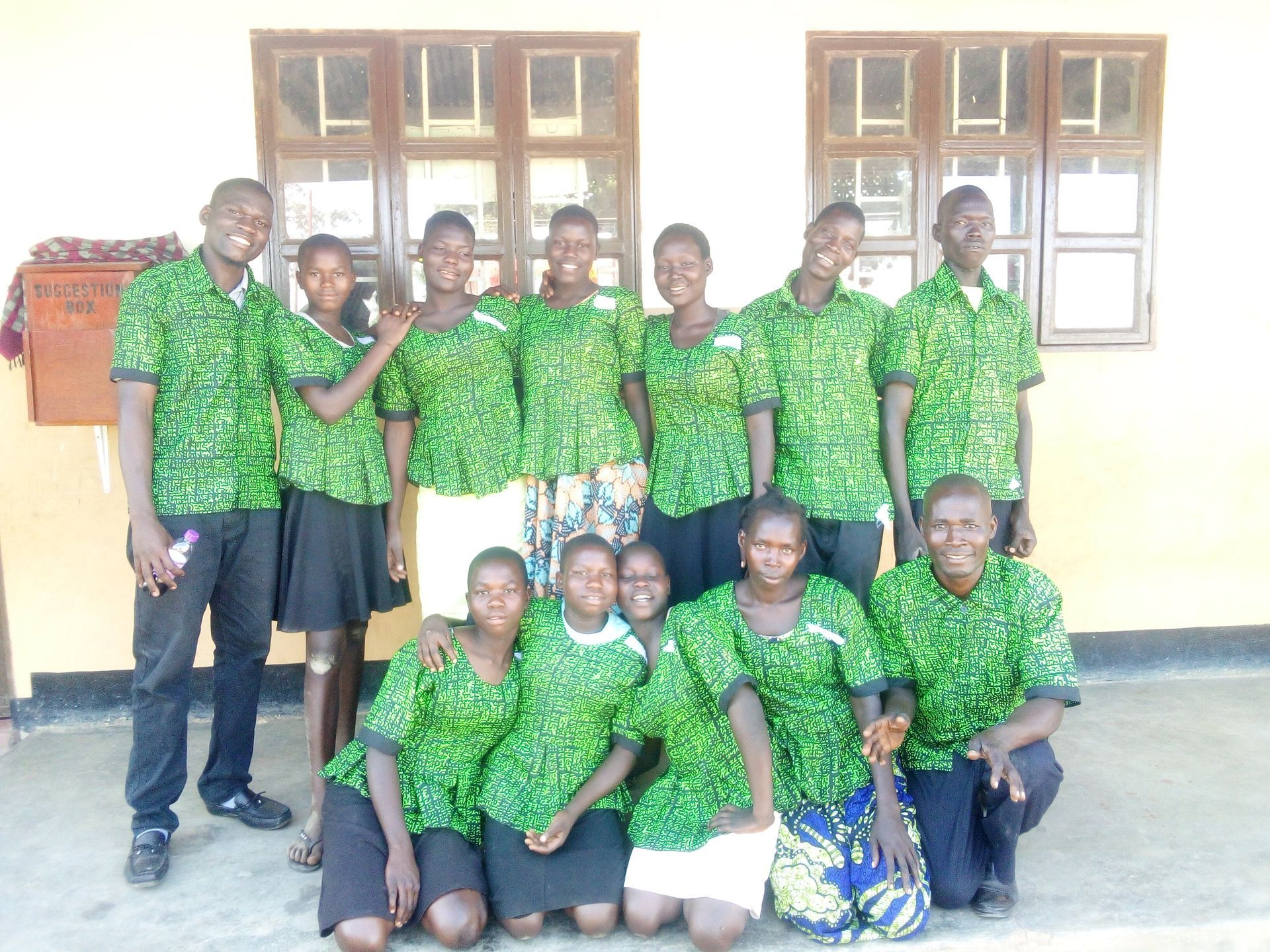 A group of people in green shirts are posing for a picture