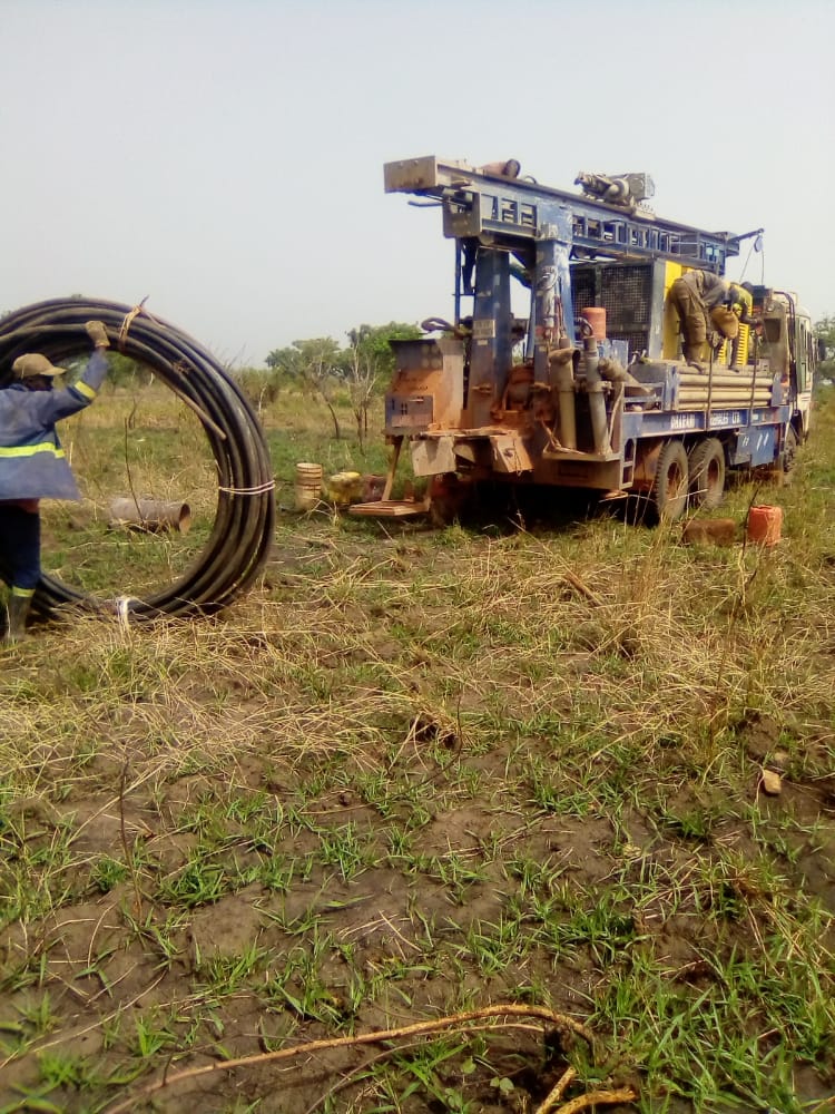 A man is standing in front of a large machine in a field.
