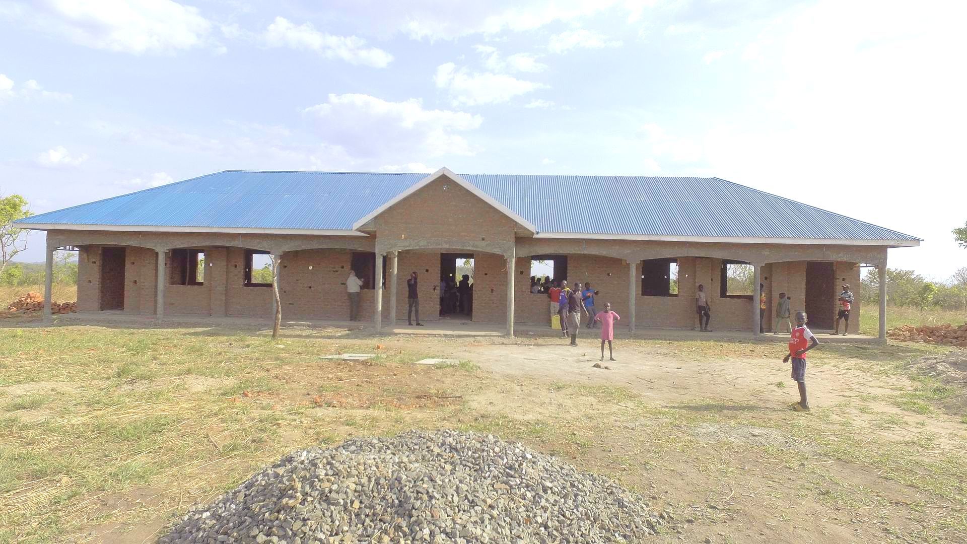 A group of people are standing in front of a building under construction.