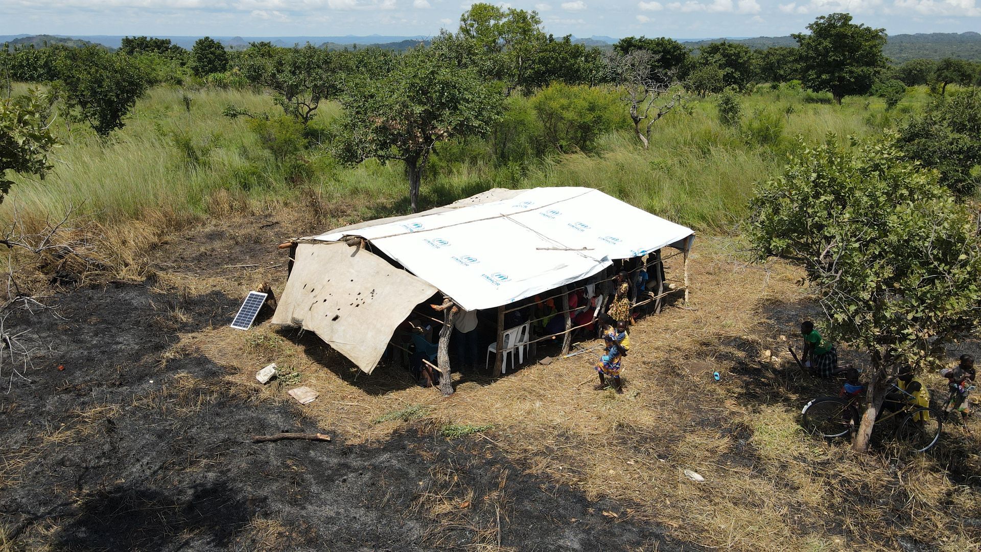 An aerial view of a house in the middle of a field.