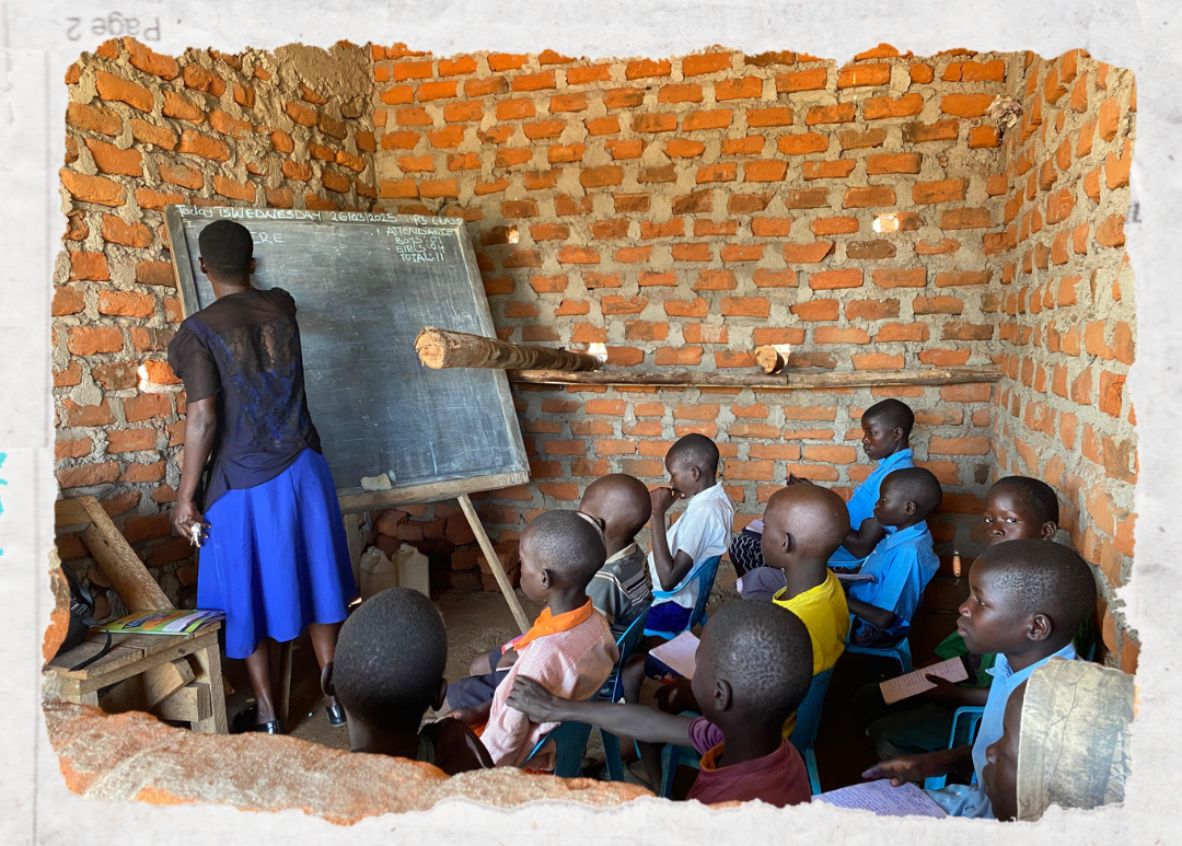 Teacher writing on chalkboard in a brick classroom with seated students watching attentively