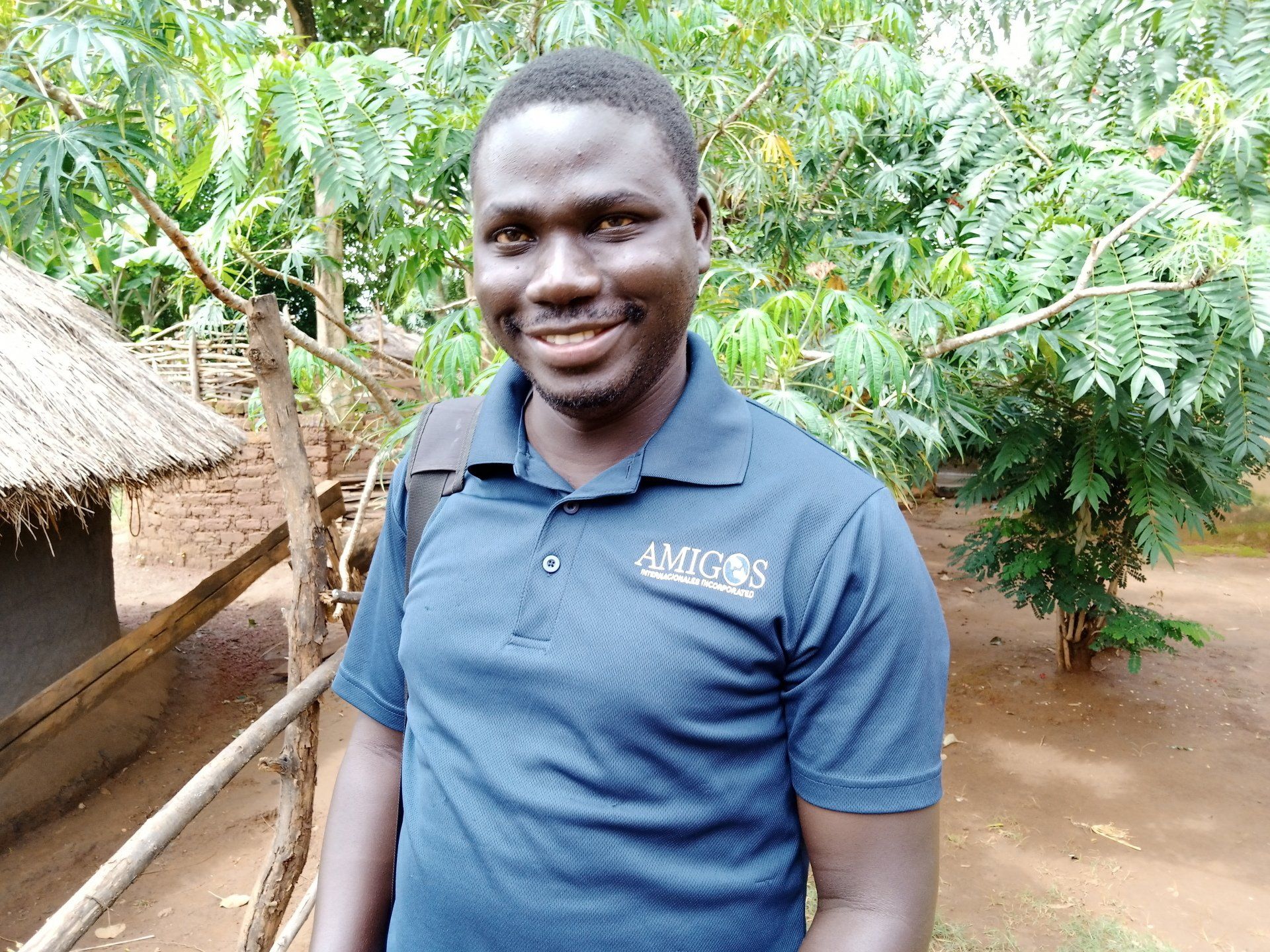 A smiling person in a blue polo shirt featuring the word 