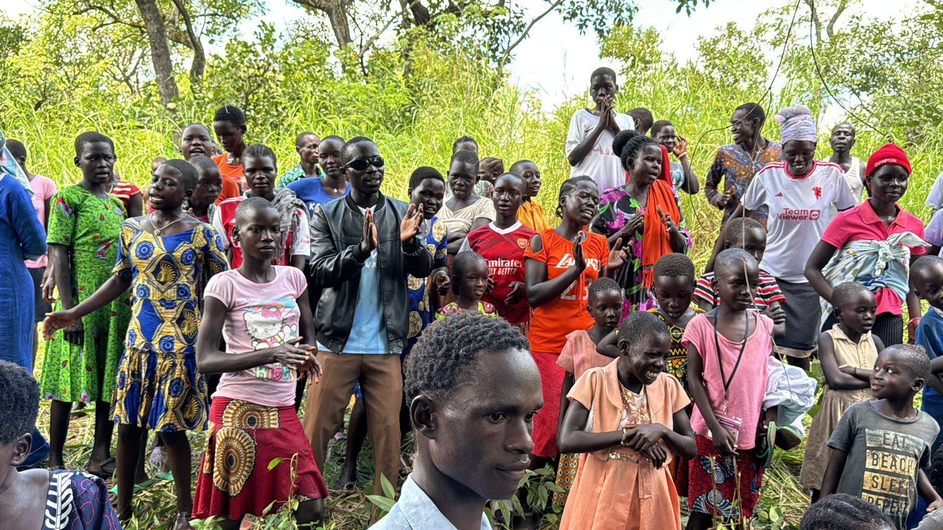 A large group of people are standing in a field.