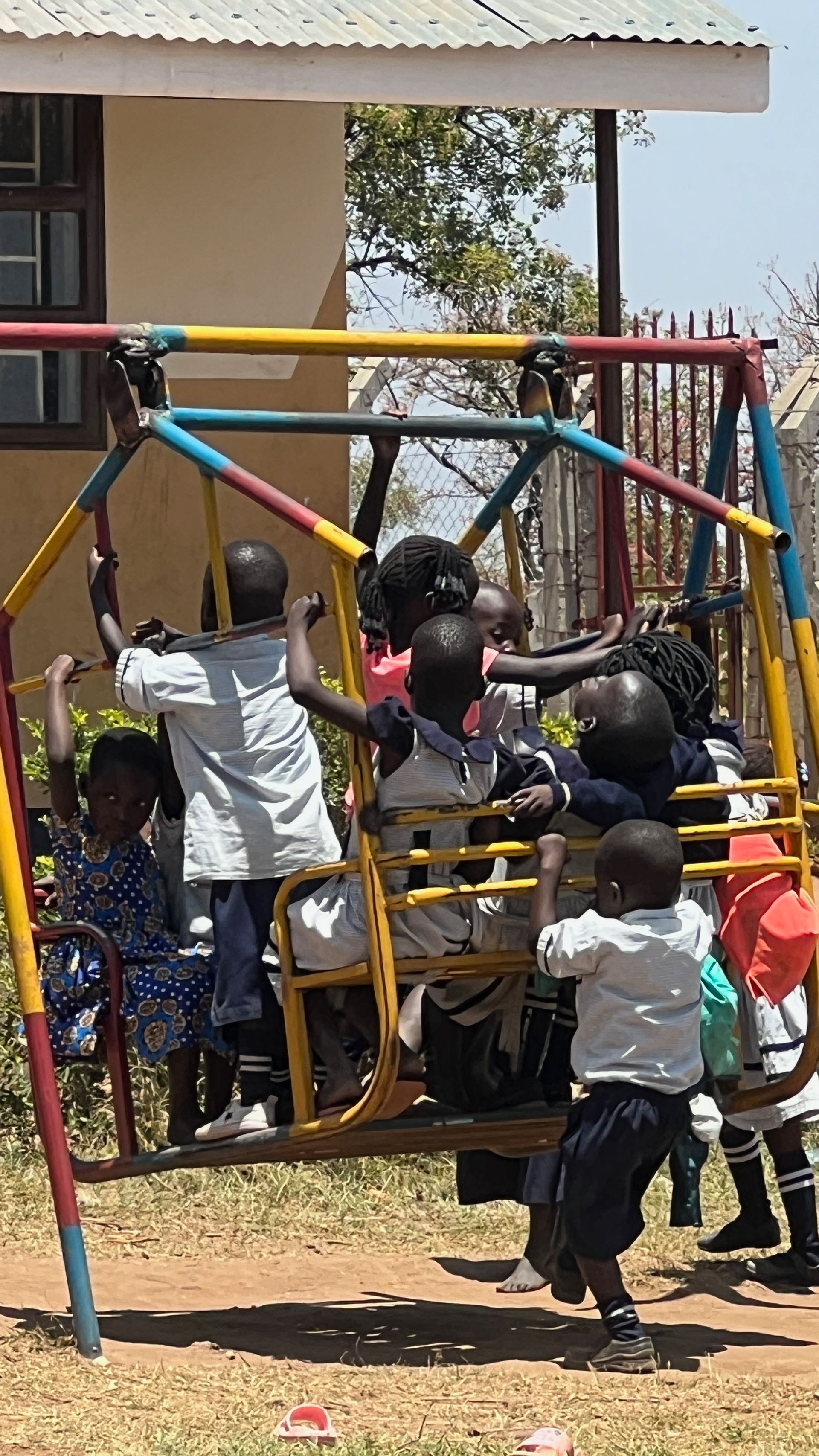 A group of children are playing on a swing set.