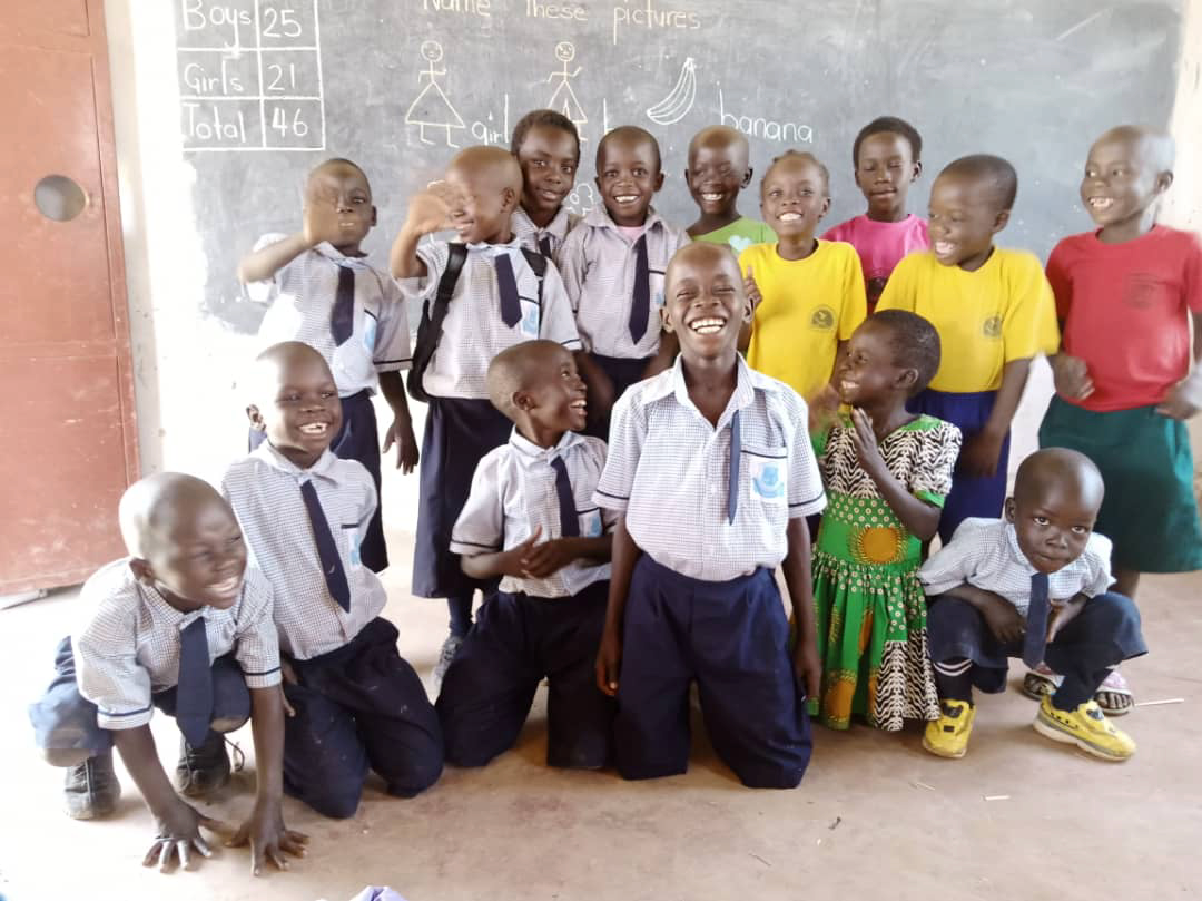 A group of children are posing for a picture in a classroom.