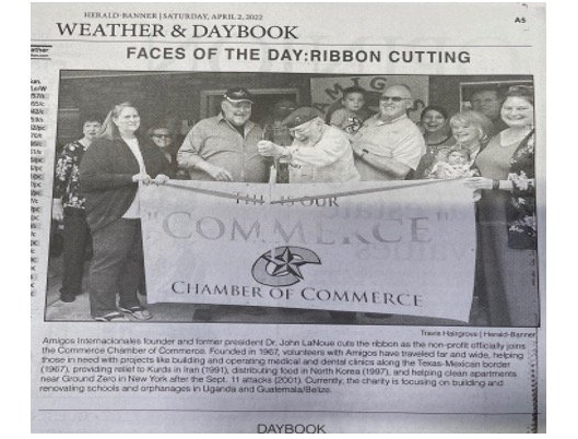 A group of people holding a banner that says chamber of commerce