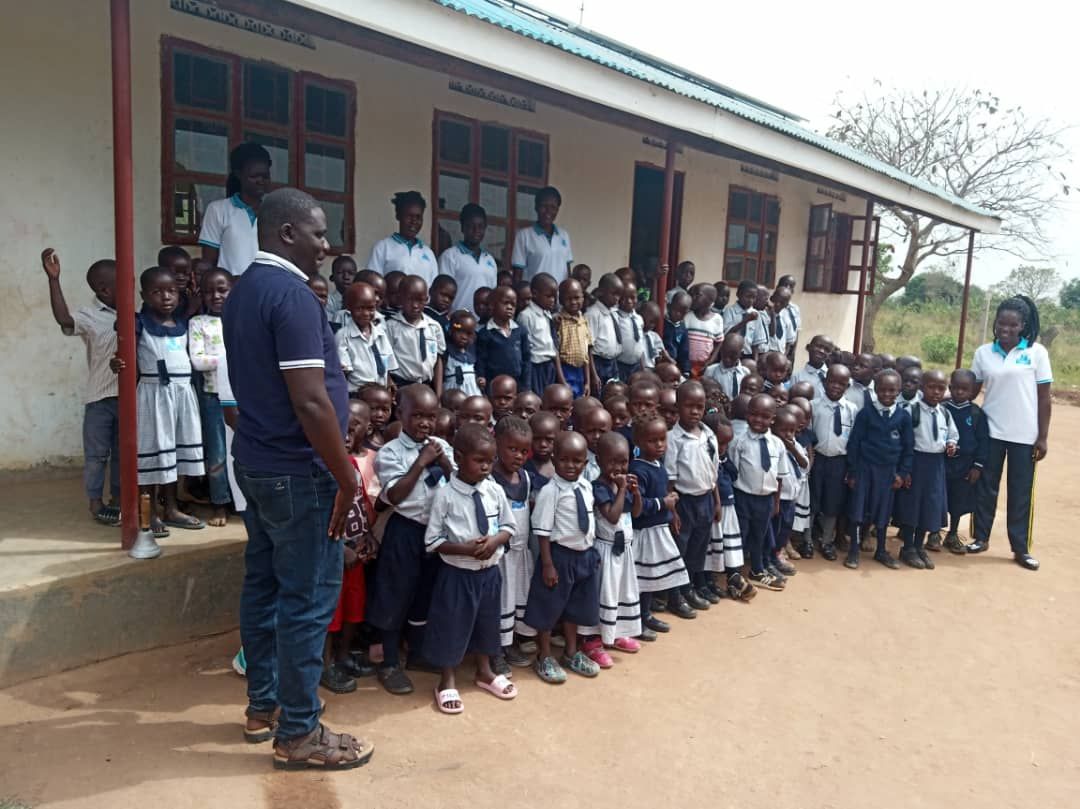 A group of children are posing for a picture in front of a school building.