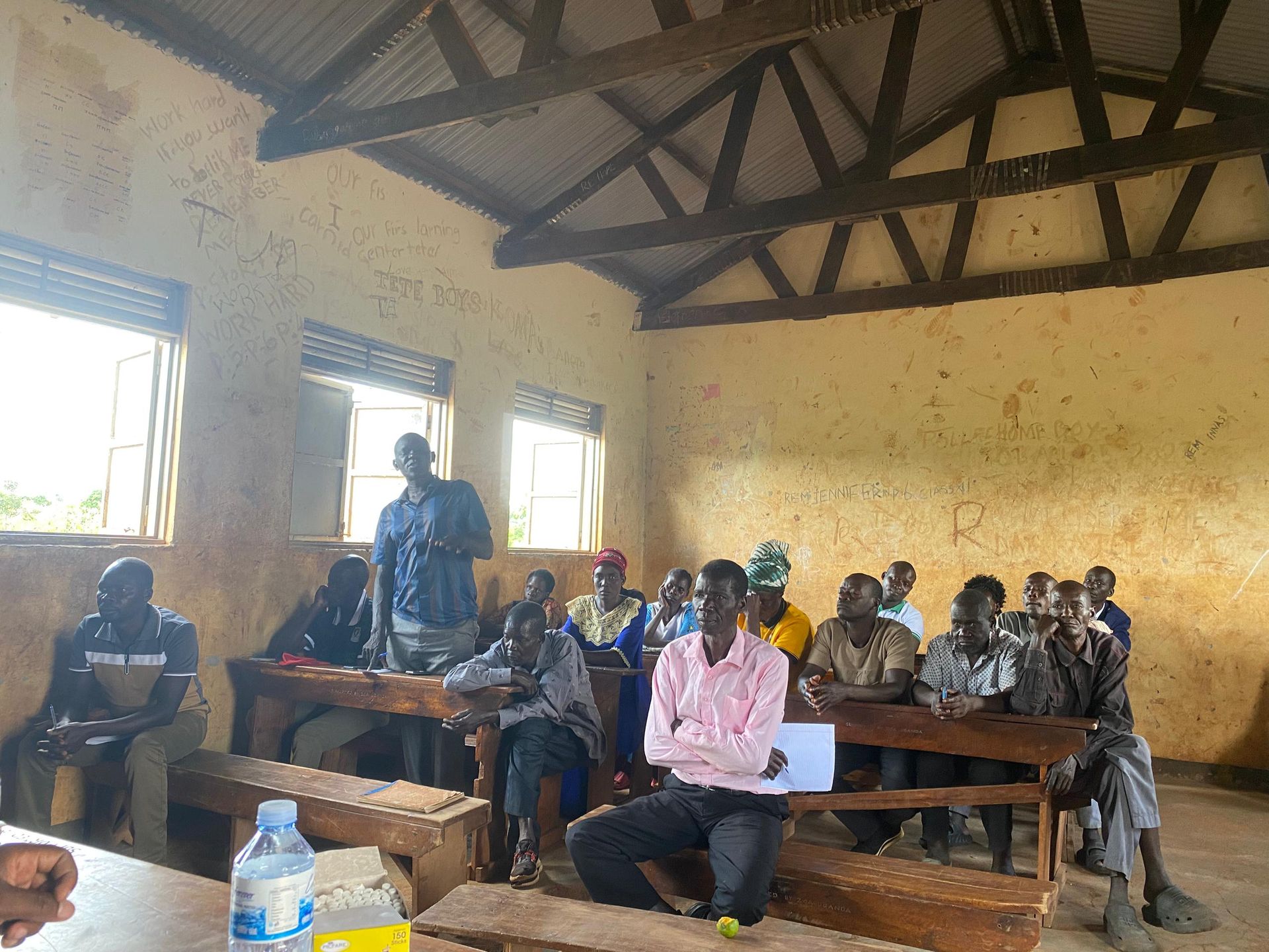 Amigos leadership meeting with village elders and community members inside a classroom at Orua Community Nursery and Primary School, Korobar Village, June 2026.