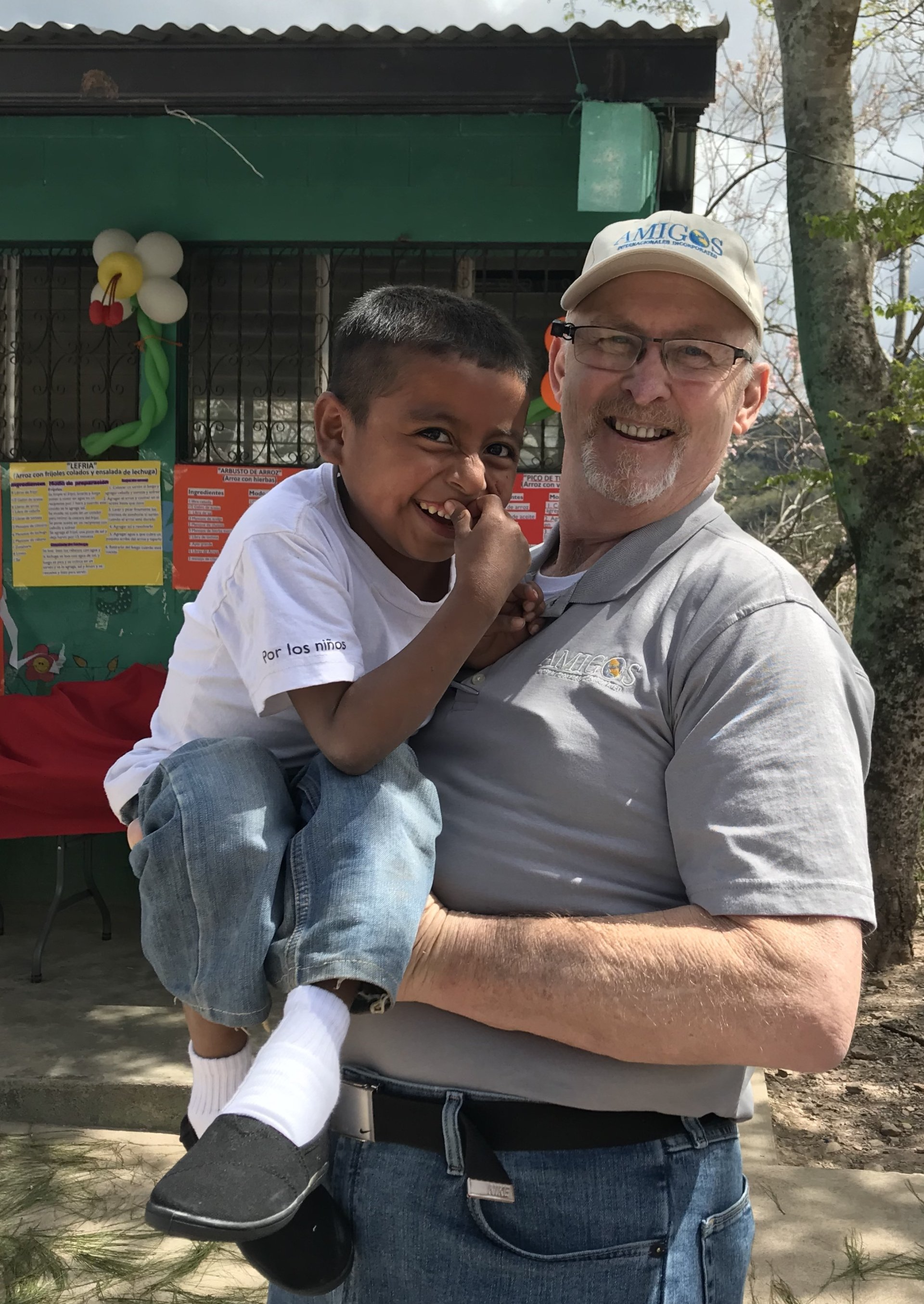 A man is holding a little boy in his arms.