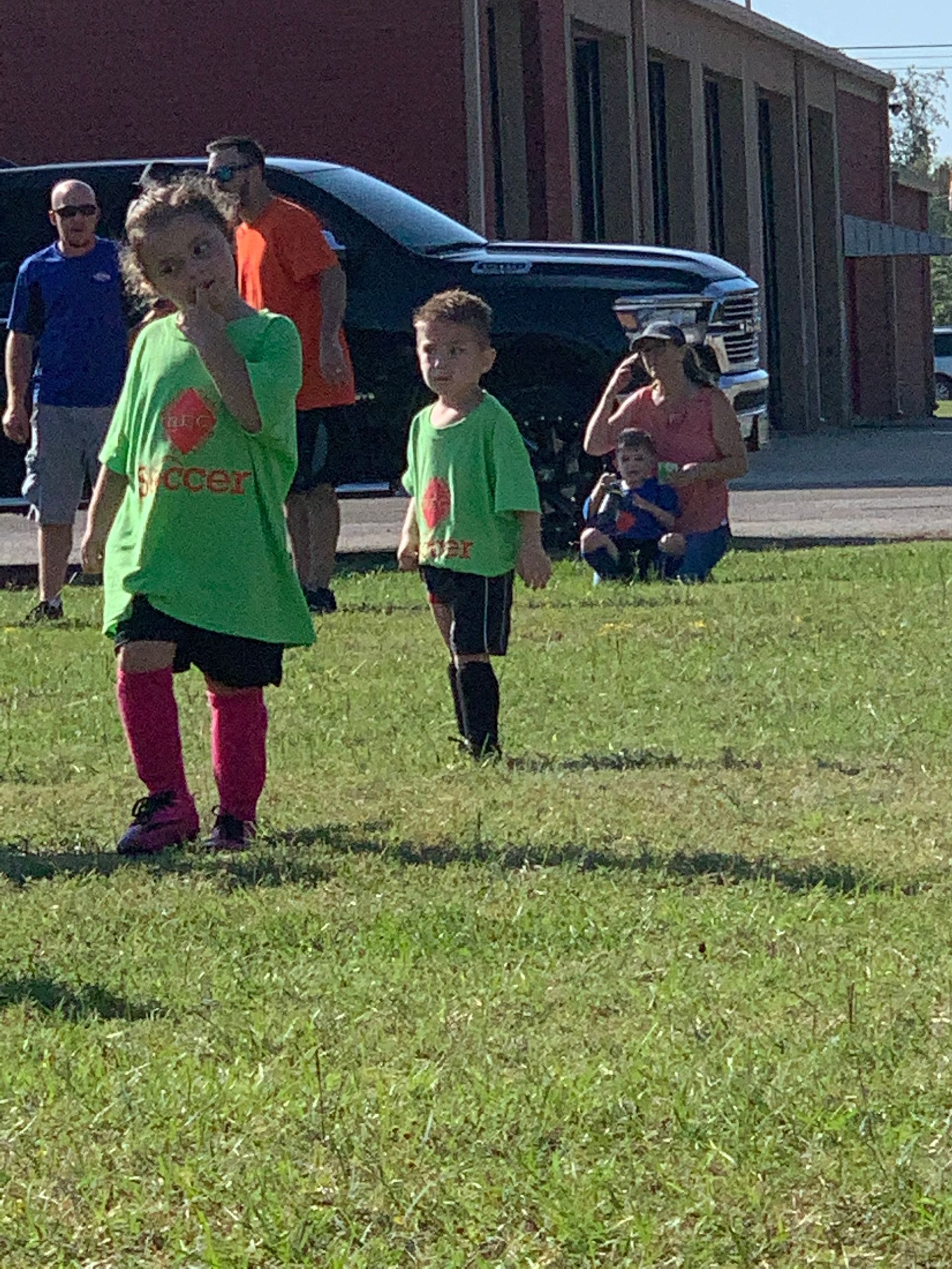 A group of children are playing soccer in a field.