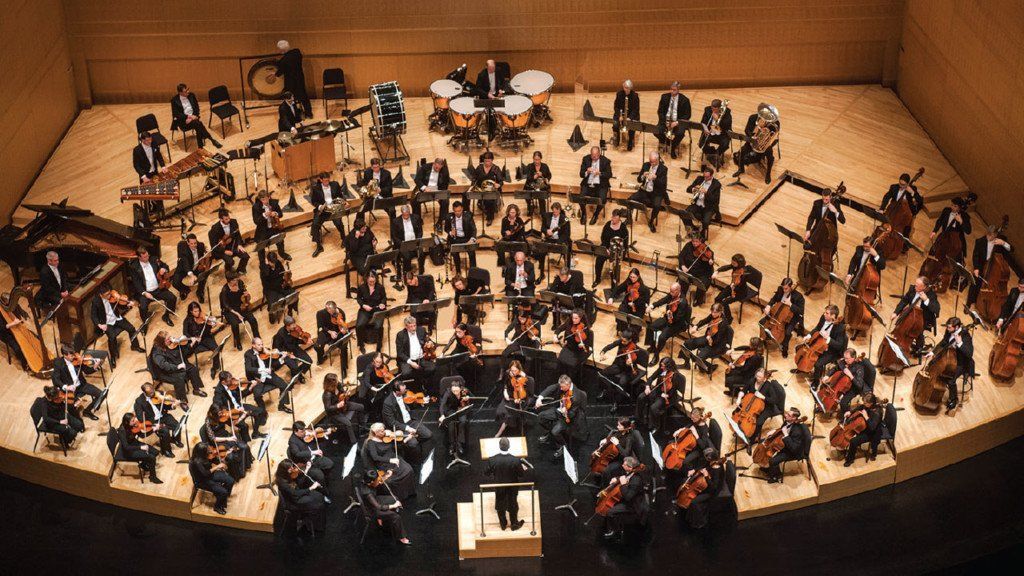 A large orchestra is playing in a large auditorium.