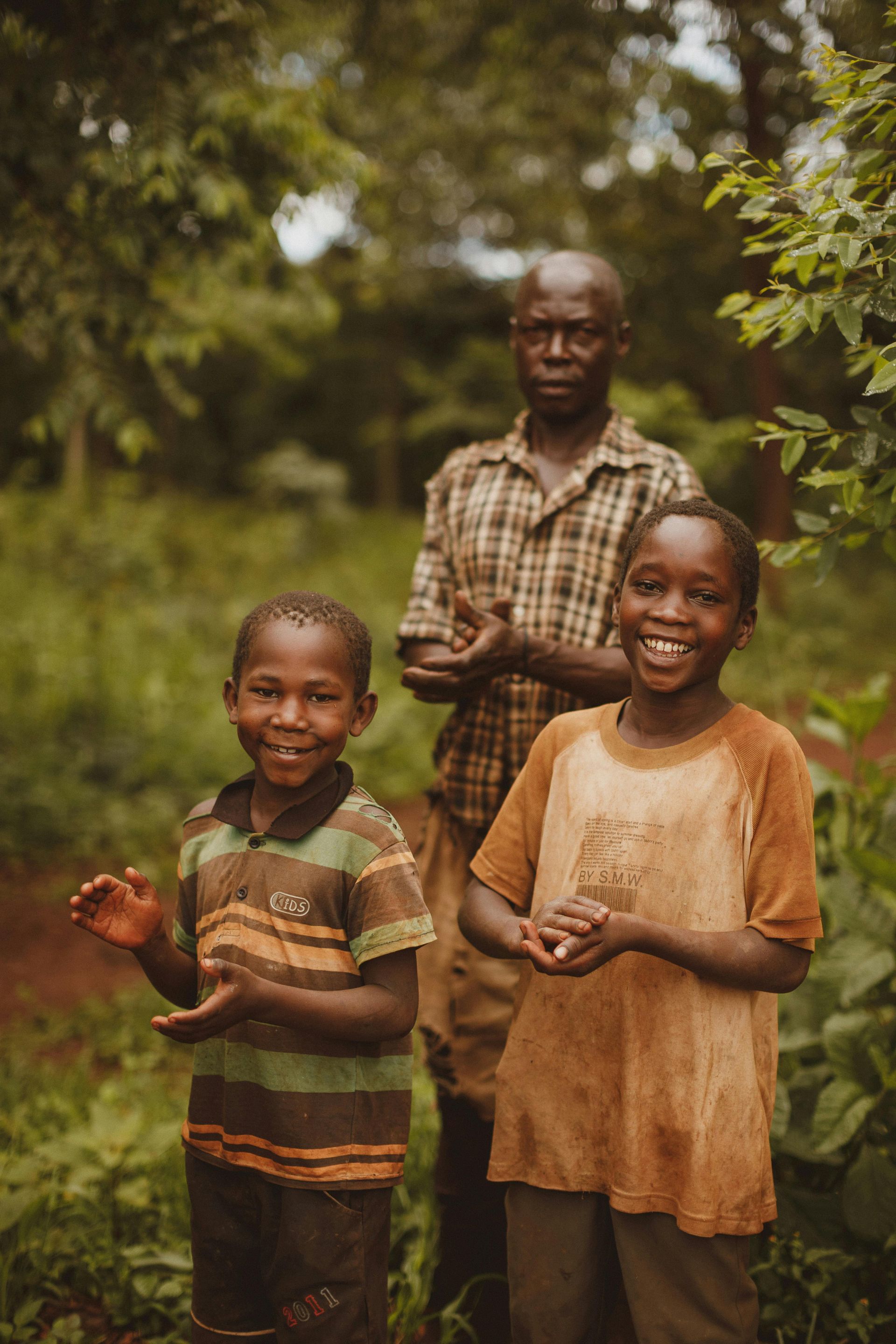 A group of children are standing next to each other in a field.