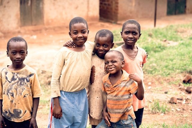 A group of children are posing for a picture in a field.