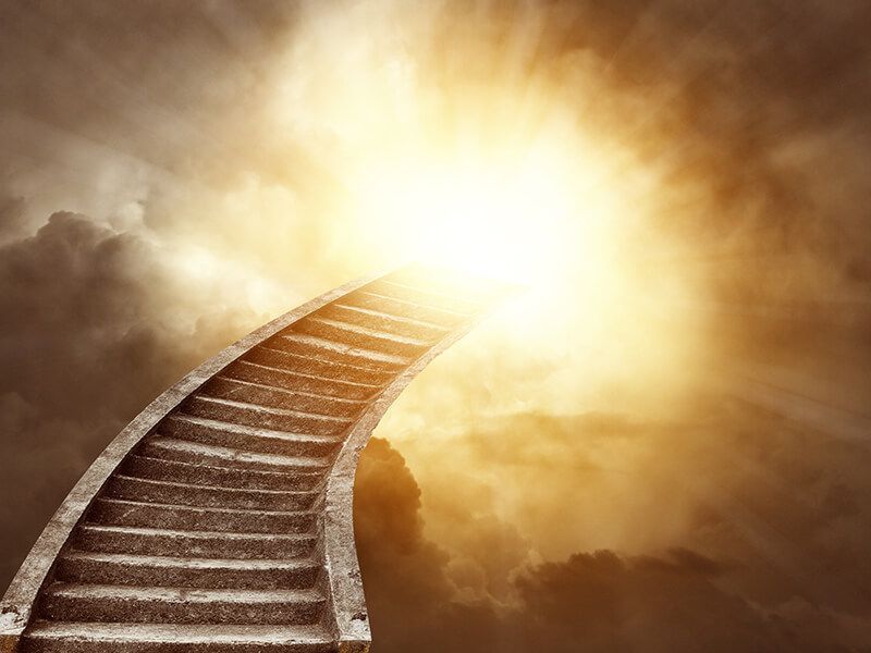 A staircase leading up to a bright light in the sky.