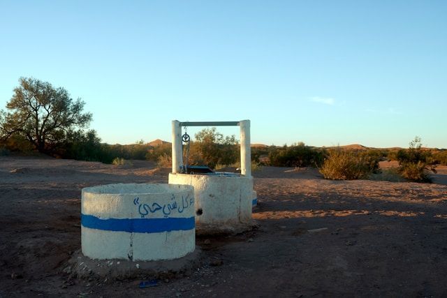 Two wells in the desert with arabic writing on them