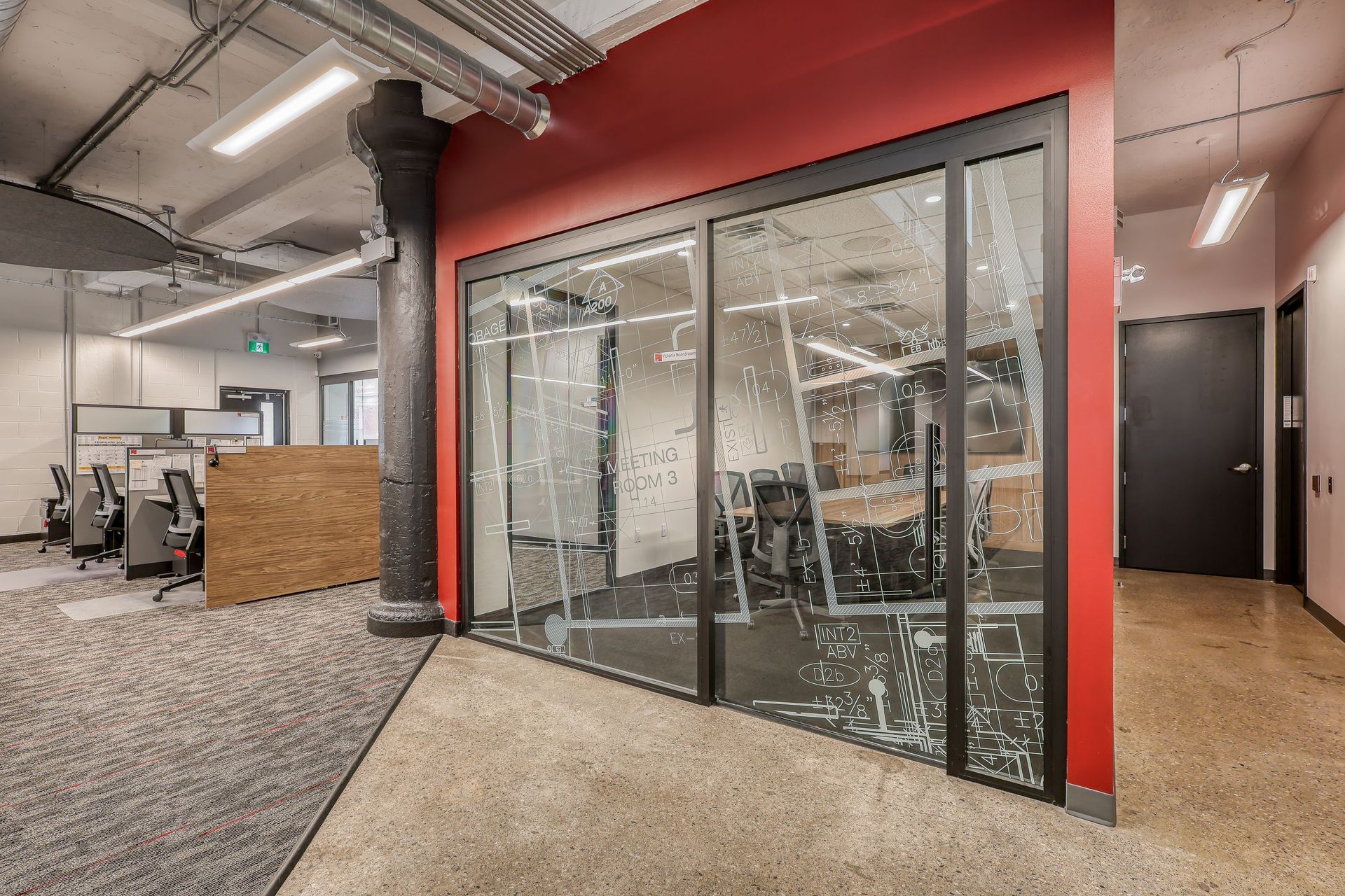 SBM Kitchener office. A large office with a lot of windows and a red wall.