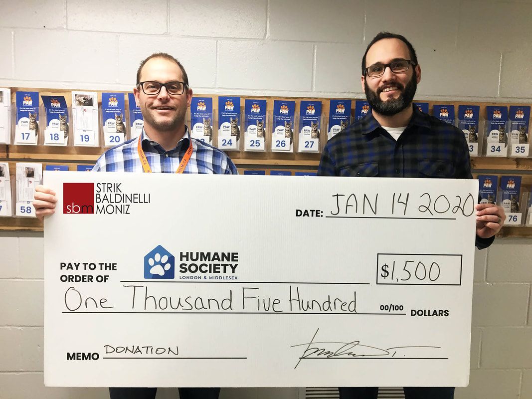 Two men are holding a check from the humane society