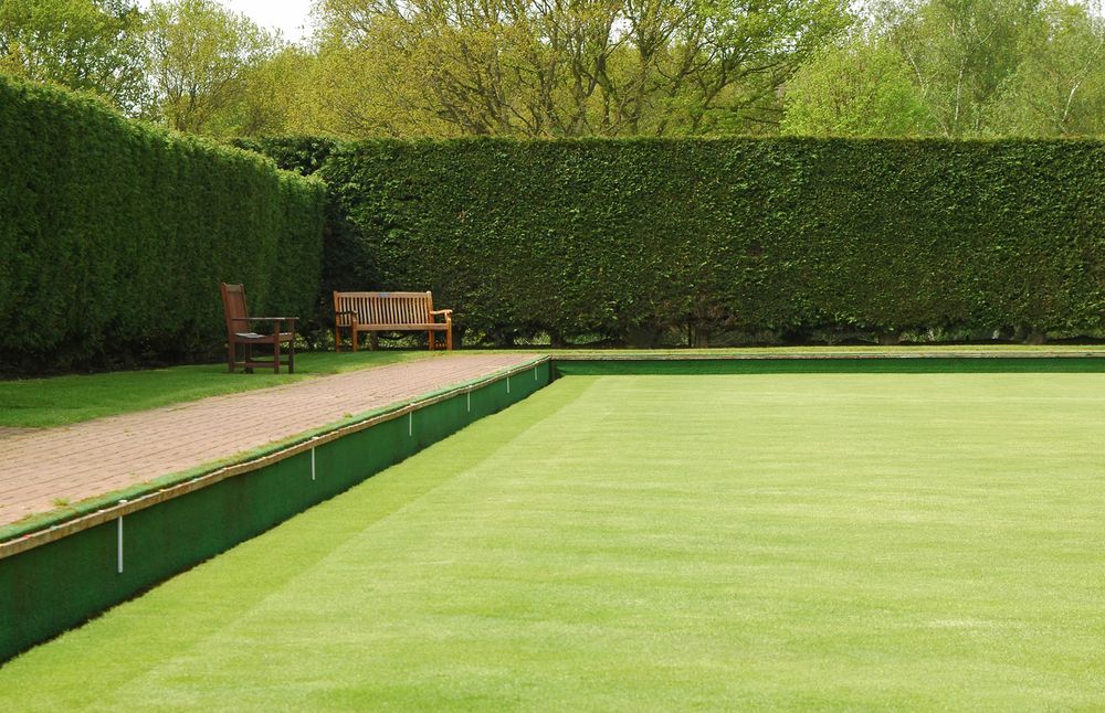 Green Lawn with A Brick Path, a Bench, and A Tall Hedge in A Park — Young's Lawn Care In West End, QLD