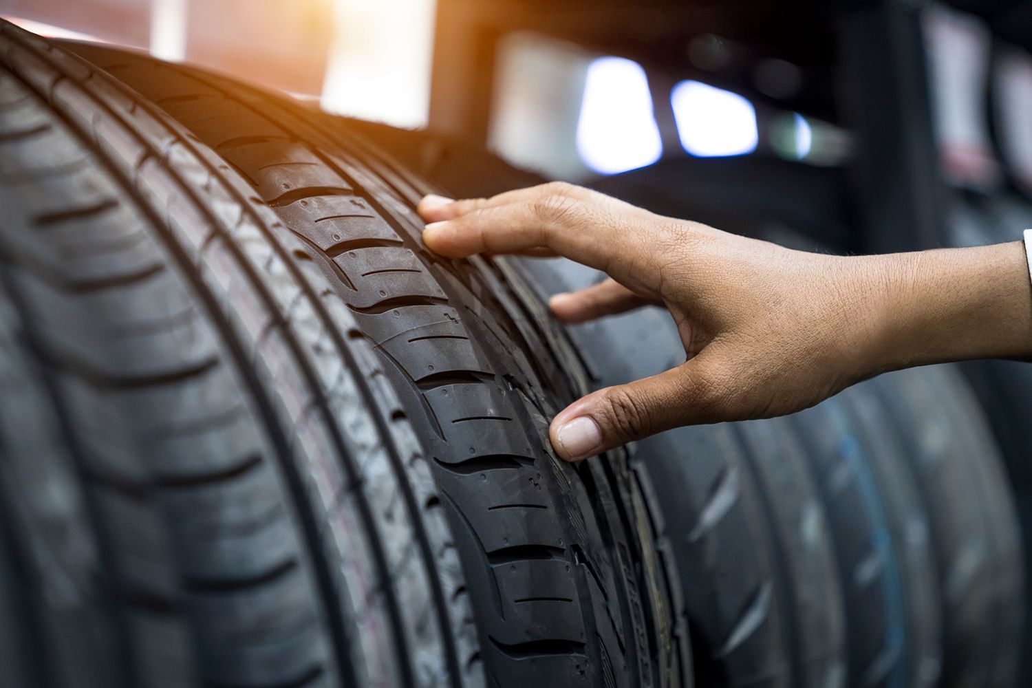 A person is touching a tire in a store.