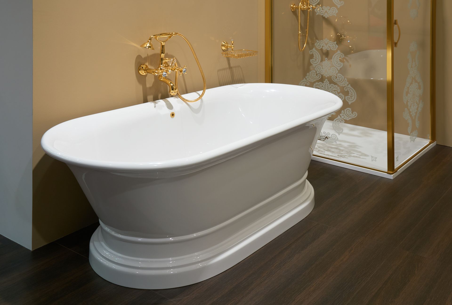 Freestanding white bathtub with gold fixtures in a modern bathroom showroom