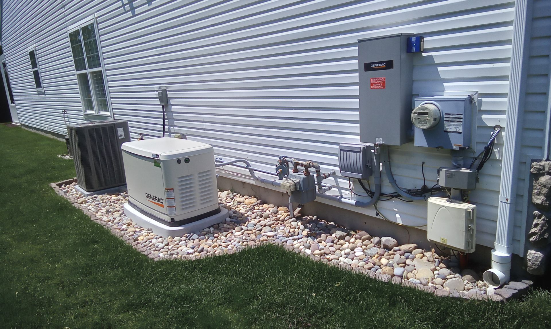 Air conditioner units and electrical meter mounted beside a house with white siding.