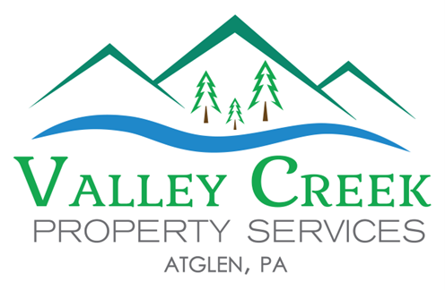 Logo for Valley Creek Property Services, featuring green mountains, a blue creek, and text.