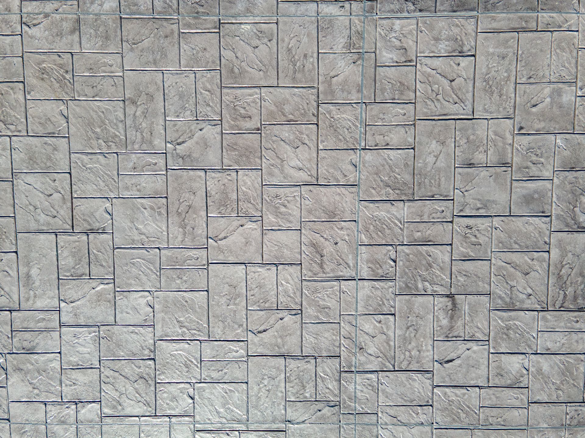 Gray stone wall with a repeating rectangular tile pattern