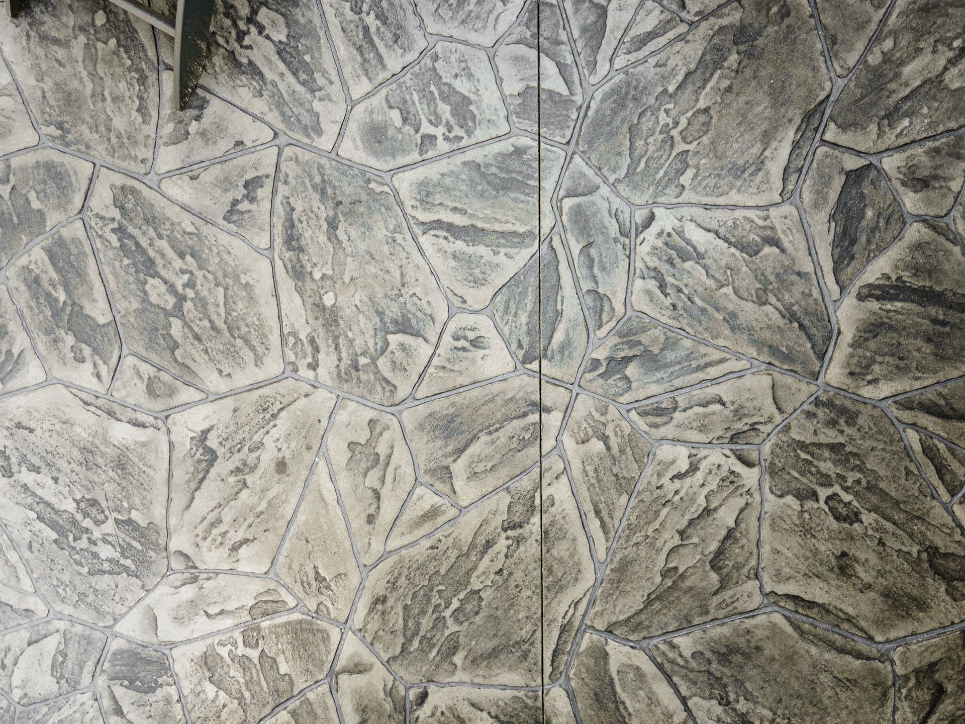 Gray stone tile pattern with irregular geometric shapes and textured grout lines