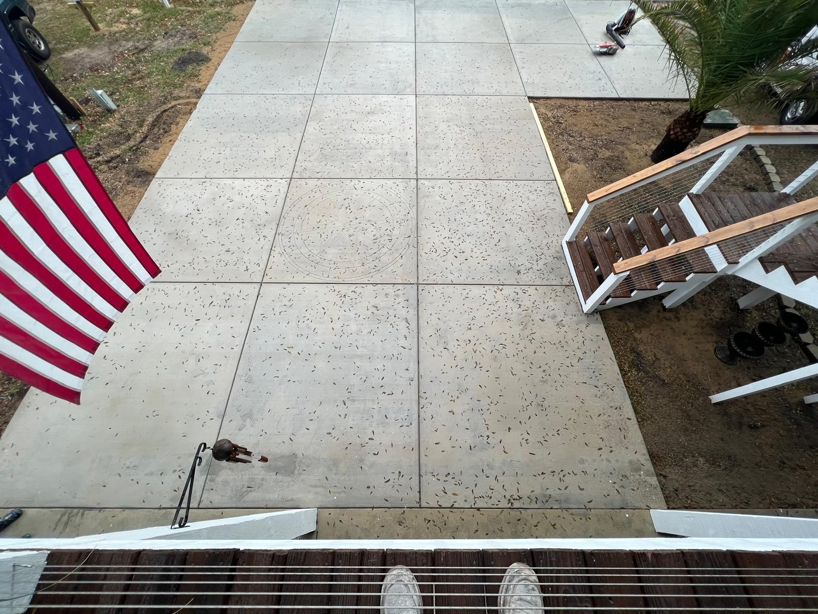 Concrete front walkway with an American flag on the left and steps with a railing on the right