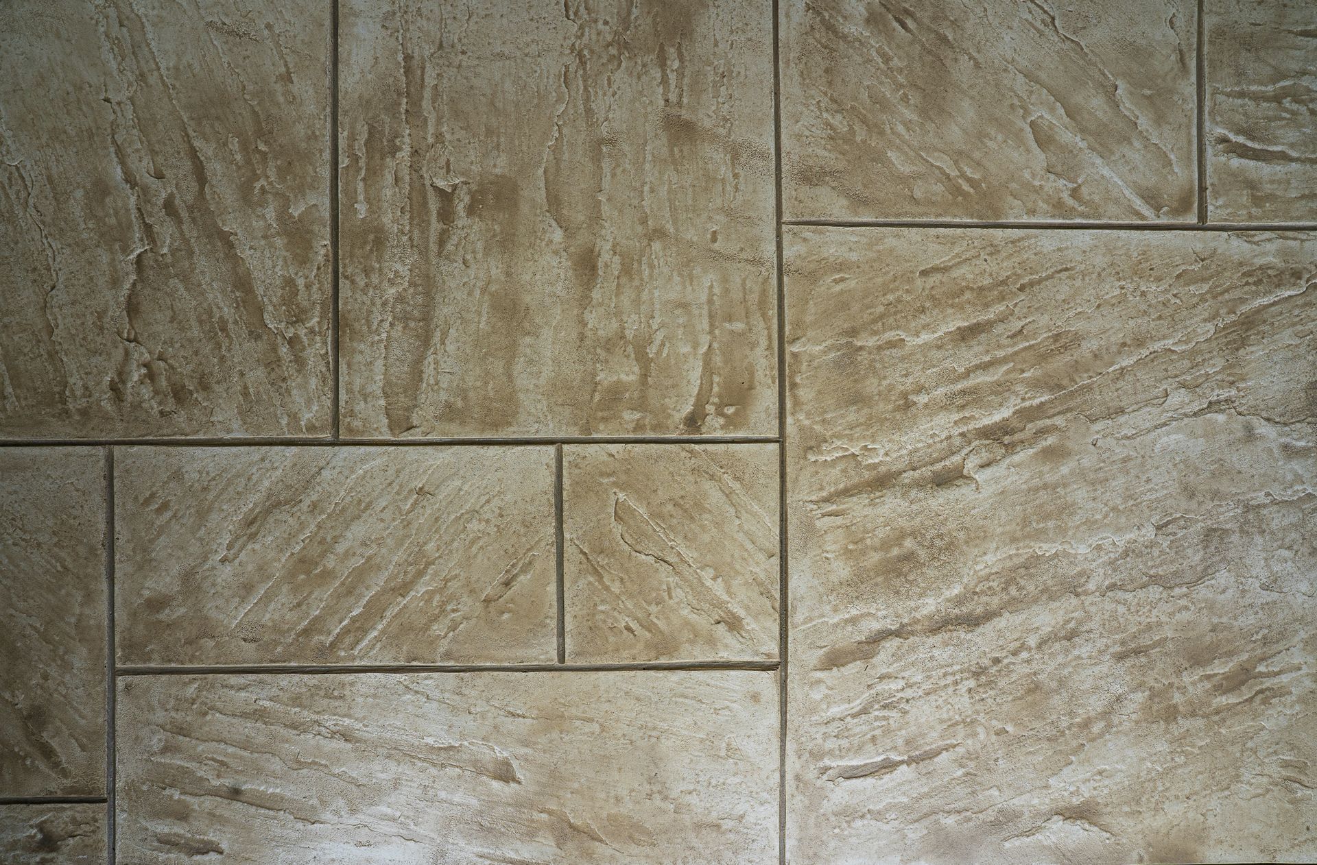 Tan and beige stone tile wall with rectangular blocks and textured surface.