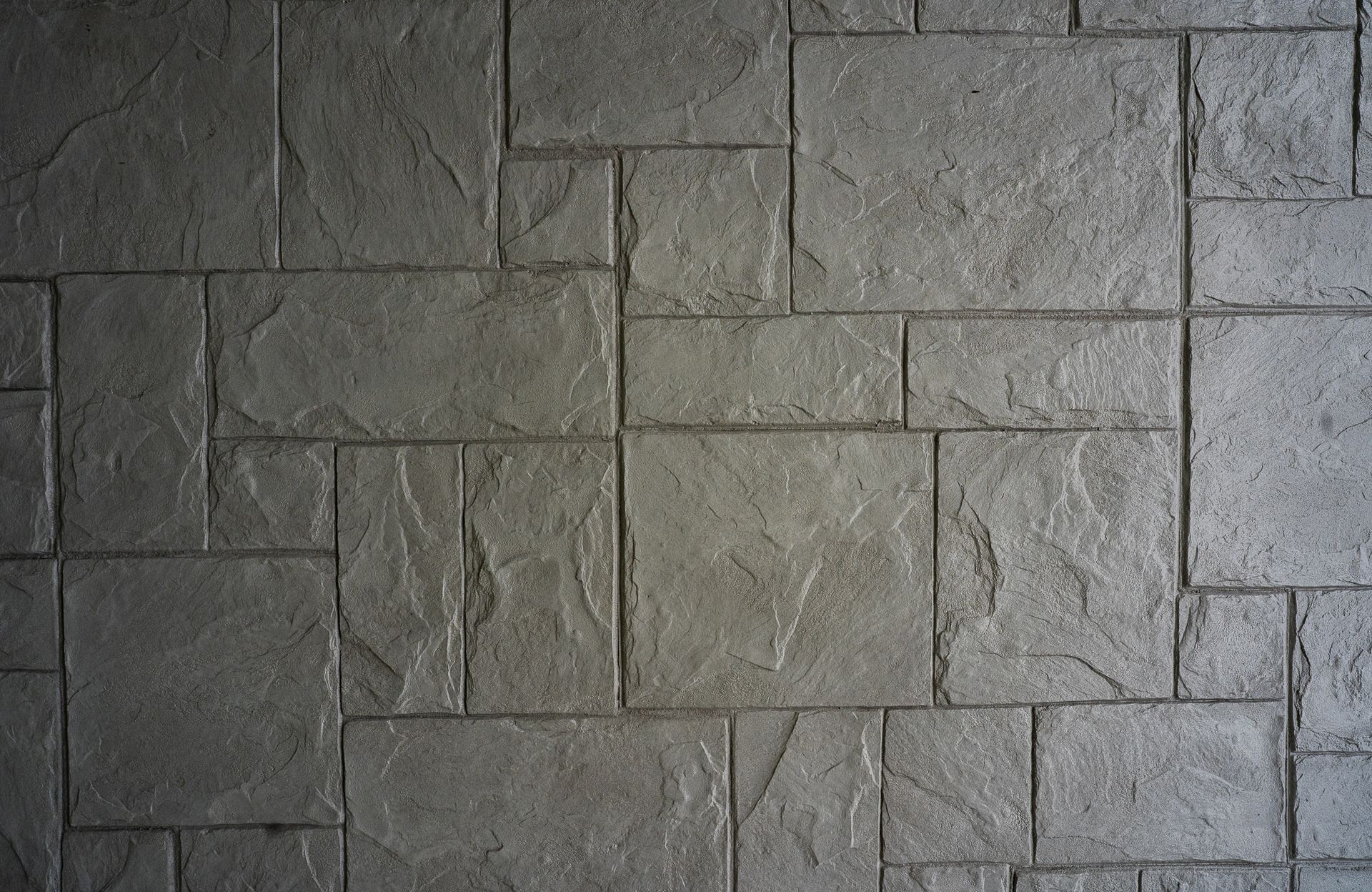 Gray stone wall with rectangular blocks and rough texture