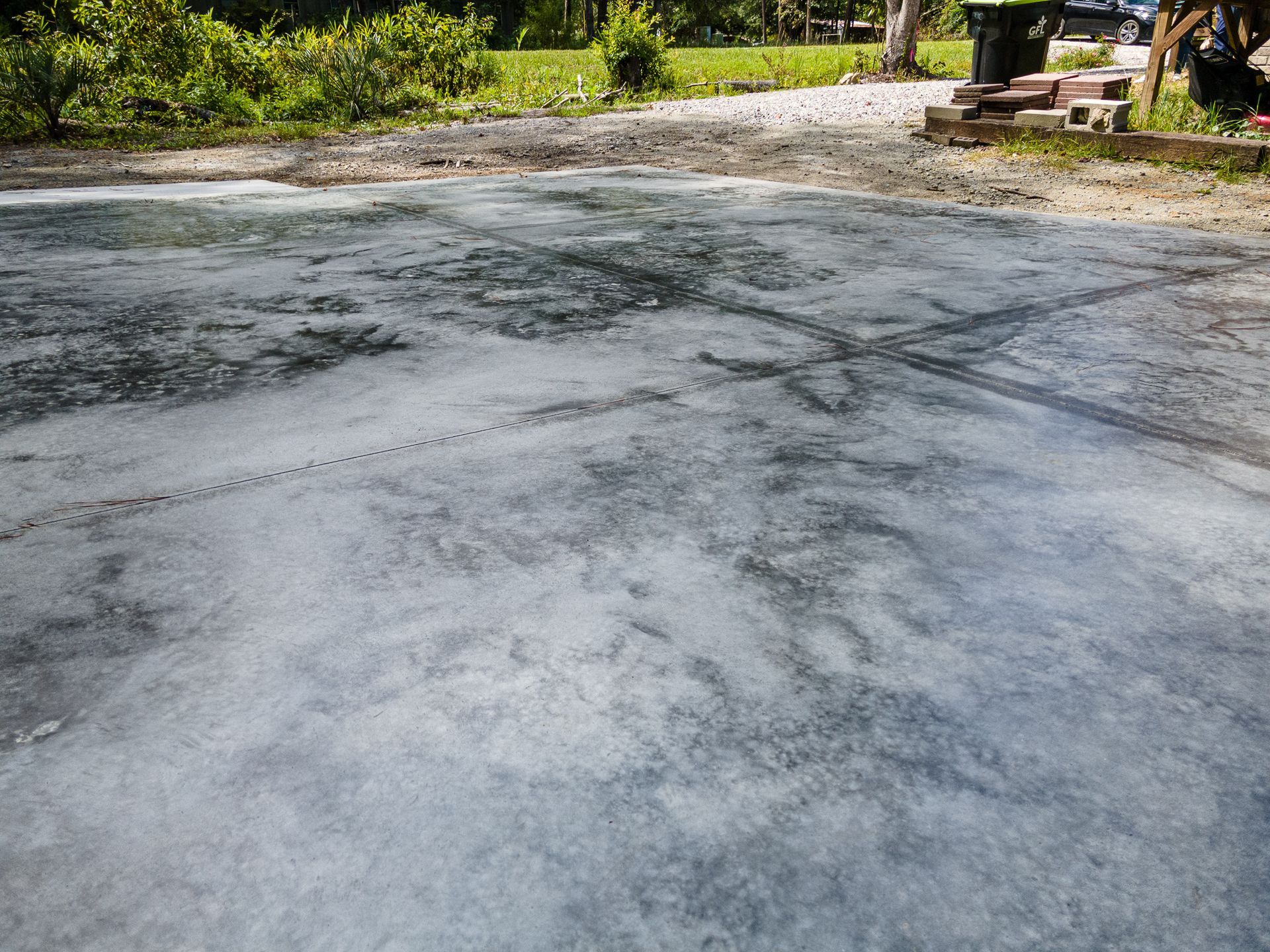 Empty paved driveway with trees and greenery in the background