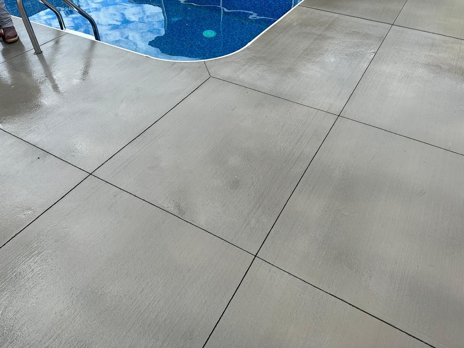 Gray pool deck tiles beside blue swimming pool water