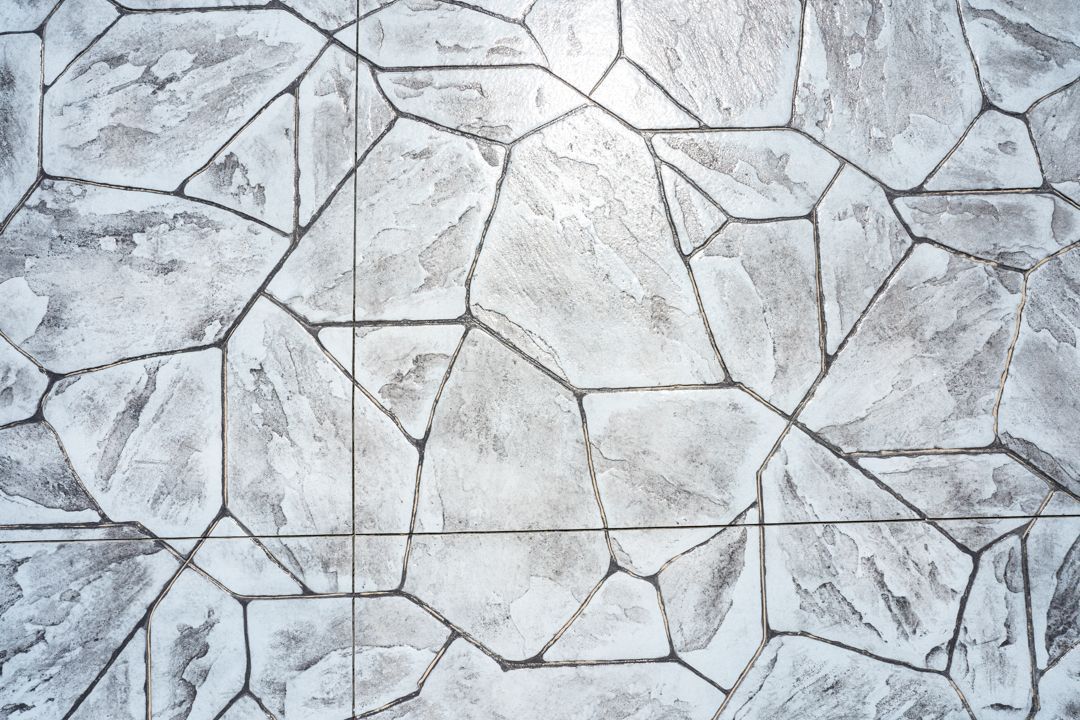 White cracked stone or concrete surface with irregular polygonal pattern